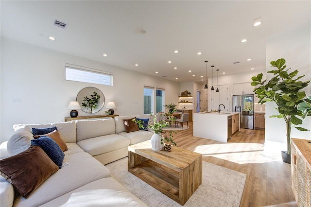 living area featuring light wood-type flooring, visible vents, plenty of natural light, and recessed lighting