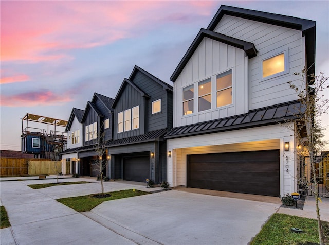 view of front of house featuring a garage, fence, concrete driveway, board and batten siding, and a standing seam roof