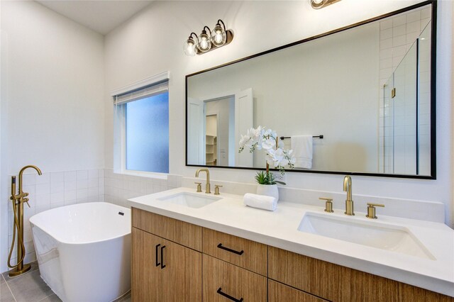 full bathroom featuring a soaking tub, tile walls, a sink, and tile patterned floors