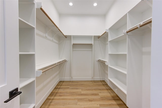 walk in closet with light wood-style floors