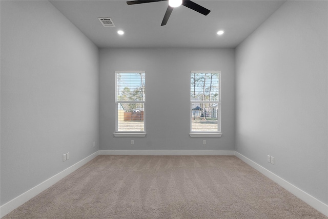 spare room with recessed lighting, visible vents, light carpet, and baseboards