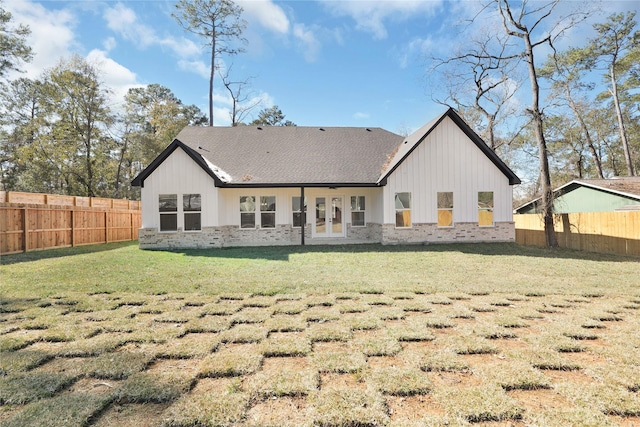 rear view of house featuring a fenced backyard, a yard, brick siding, and roof with shingles