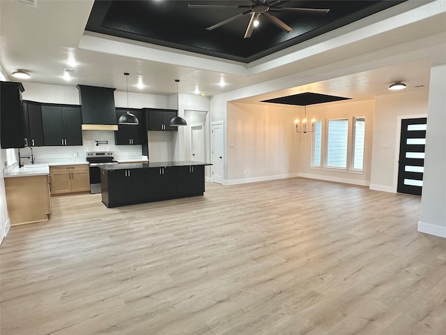 kitchen featuring stainless steel electric range oven, custom range hood, a tray ceiling, and open floor plan