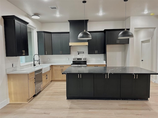 kitchen featuring stainless steel appliances, a sink, visible vents, light wood-style floors, and custom range hood