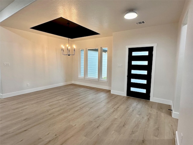 foyer with a chandelier, baseboards, visible vents, and light wood-style floors