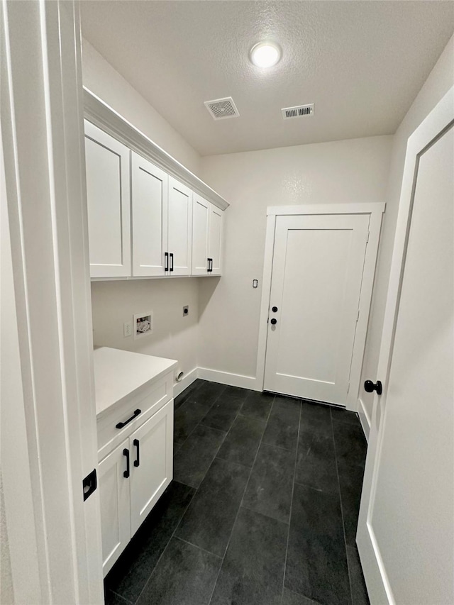 washroom with cabinet space, baseboards, visible vents, a textured ceiling, and hookup for an electric dryer