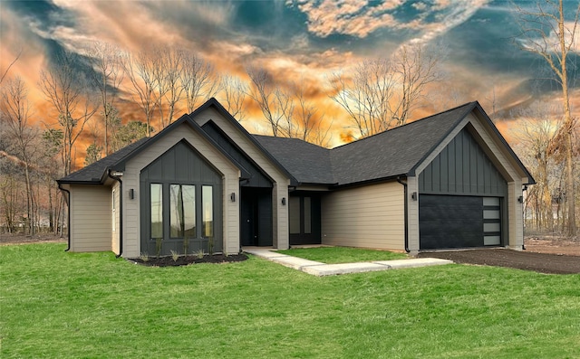 view of front of home featuring a garage, aphalt driveway, board and batten siding, and a front yard