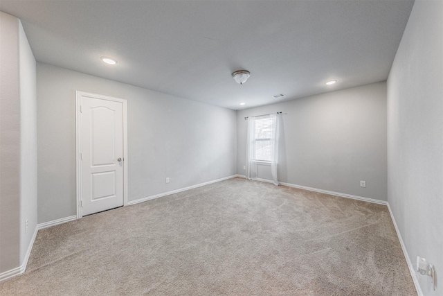 carpeted empty room with visible vents, baseboards, and recessed lighting