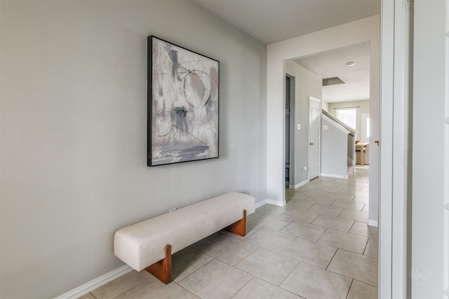 corridor with baseboards and light tile patterned floors