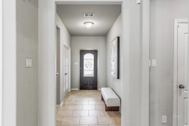 foyer featuring visible vents, baseboards, and light tile patterned flooring