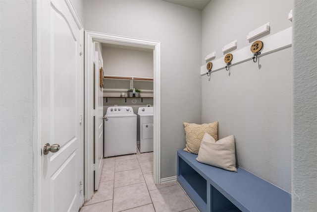 mudroom with washing machine and clothes dryer and light tile patterned floors