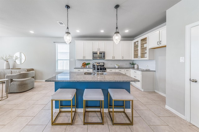 kitchen featuring light tile patterned floors, appliances with stainless steel finishes, backsplash, and visible vents