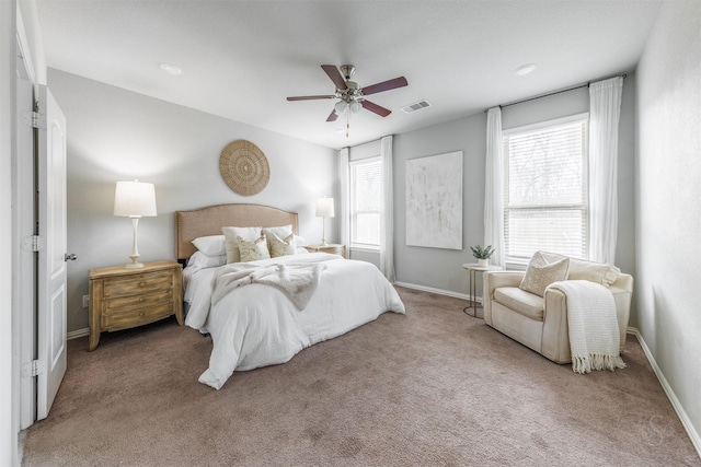 bedroom with light colored carpet, visible vents, baseboards, and multiple windows