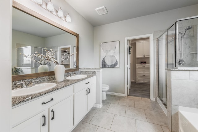 bathroom with double vanity, a stall shower, a sink, and visible vents