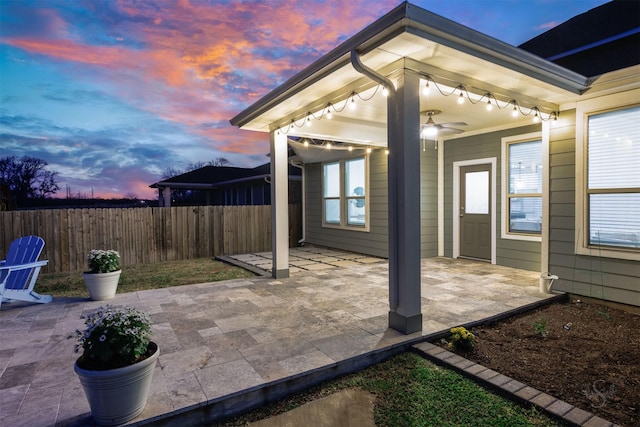 patio terrace at dusk with ceiling fan and fence