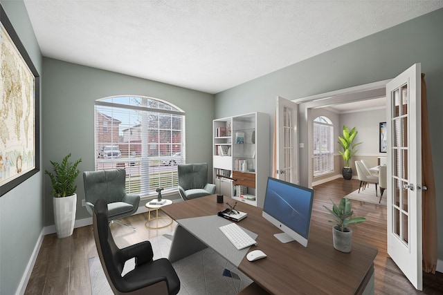 office featuring a textured ceiling, baseboards, wood finished floors, and french doors