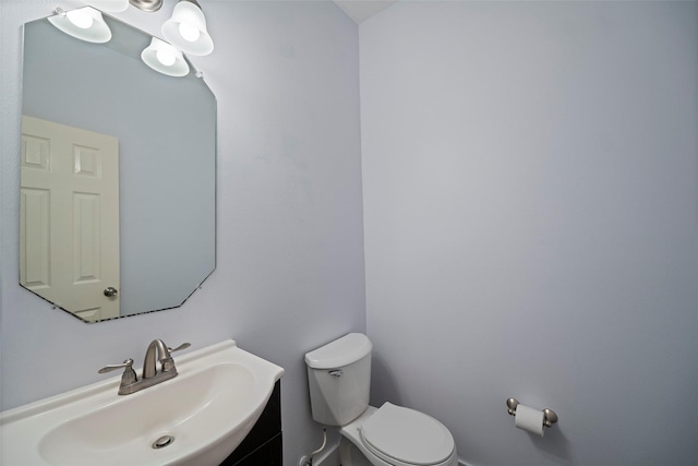 half bathroom with vanity and toilet