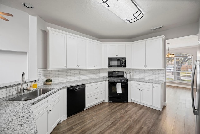 kitchen with tasteful backsplash, dark wood finished floors, black appliances, white cabinetry, and a sink