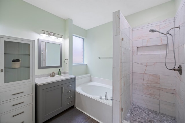 bathroom featuring a garden tub, tiled shower, and vanity