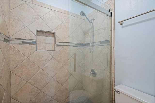 bathroom featuring a shower stall and toilet