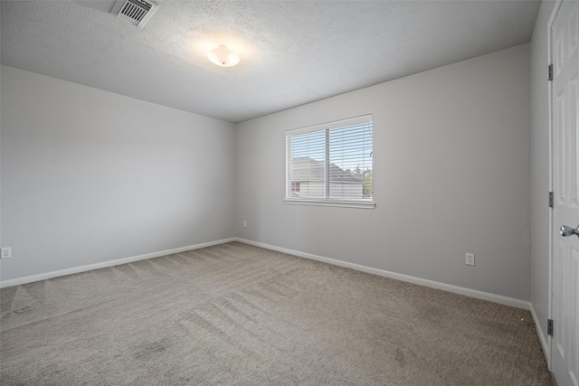 carpeted empty room with visible vents, a textured ceiling, and baseboards