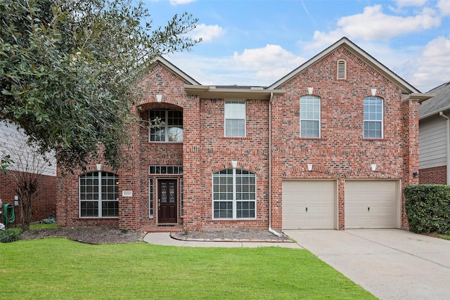 traditional-style home featuring a front yard, concrete driveway, brick siding, and an attached garage