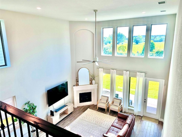 living room with recessed lighting, plenty of natural light, wood finished floors, and a fireplace