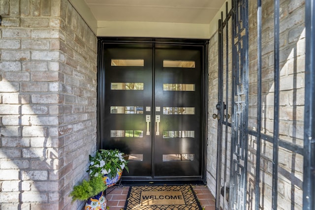 entrance to property featuring french doors and brick siding