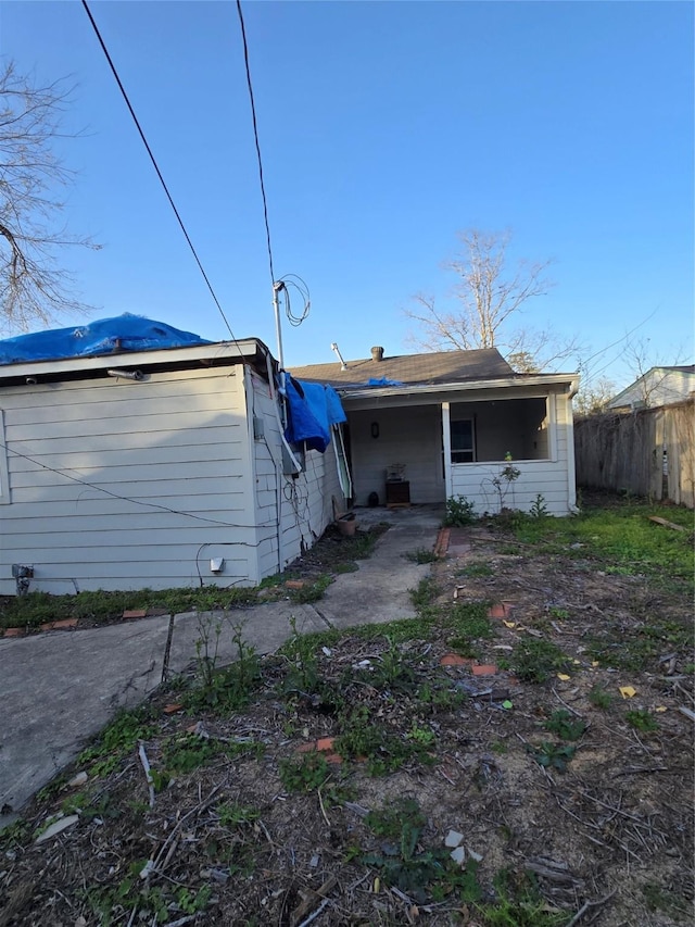 rear view of house featuring fence