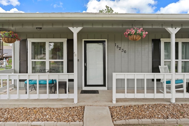 view of exterior entry featuring covered porch