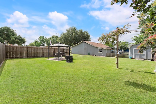 view of yard with a gazebo, a patio area, a fenced backyard, and an outdoor structure