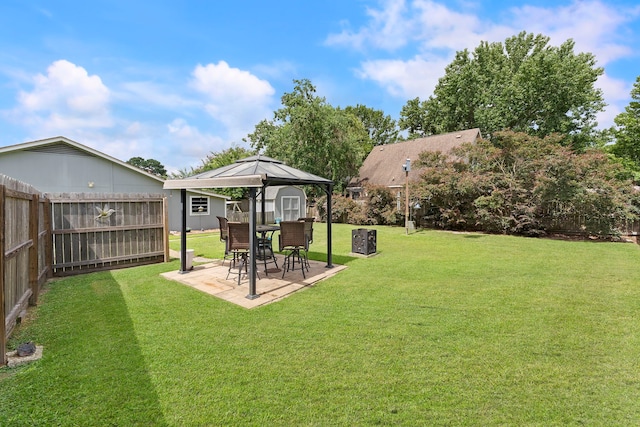 view of yard with a storage shed, a patio area, a fenced backyard, and an outdoor structure