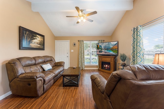 living area featuring a warm lit fireplace, lofted ceiling with beams, and wood finished floors