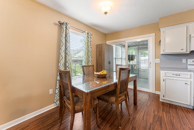 dining space with plenty of natural light, baseboards, and dark wood finished floors