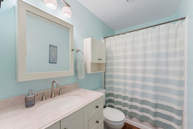 full bathroom featuring a textured ceiling, a shower with shower curtain, vanity, and toilet