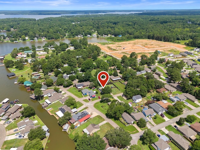 drone / aerial view with a residential view, a water view, and a wooded view