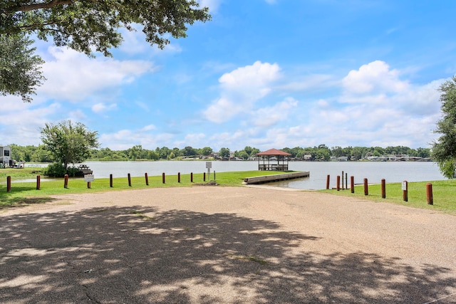 surrounding community with a boat dock and a water view