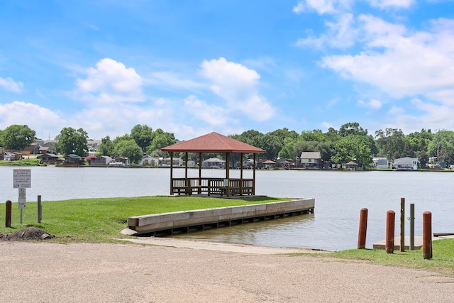 view of dock with a water view, a yard, and a gazebo