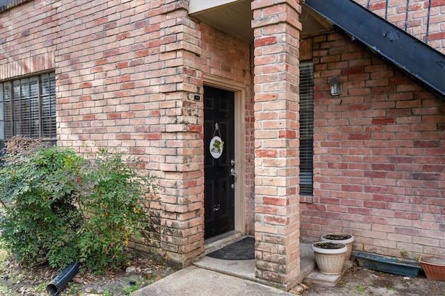 property entrance featuring brick siding