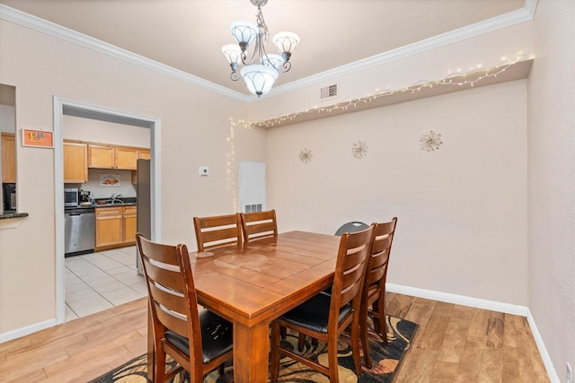 2255 Braeswood Park Dr Unit 265, Houston, TX 77030 - dining room featuring light wood-type flooring, a chandelier, crown molding, and baseboards