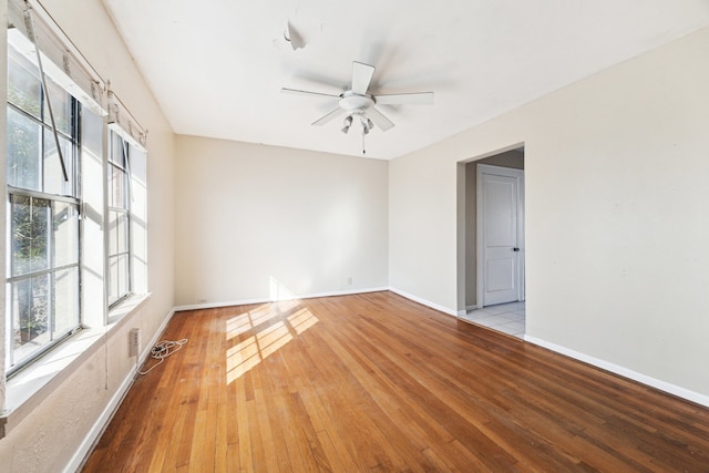 empty room featuring ceiling fan, baseboards, and hardwood / wood-style flooring