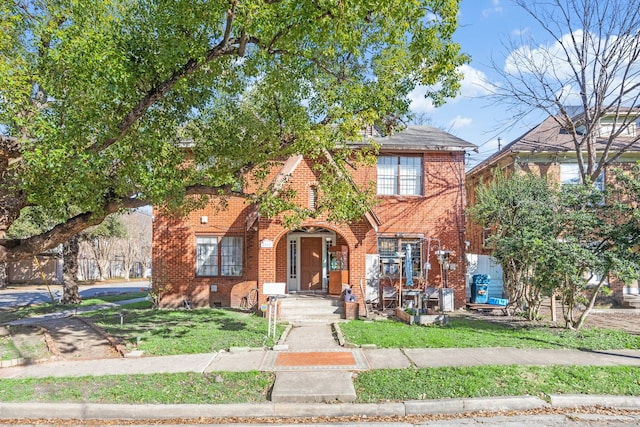 view of front of property with brick siding and a front lawn