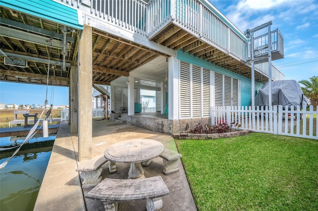 exterior space with boat lift, a dock, and fence