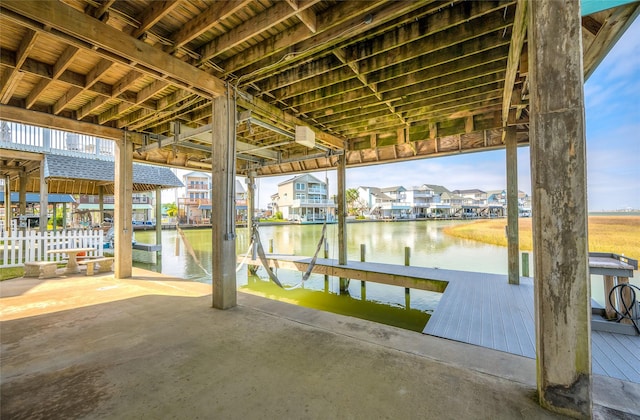 dock area with a residential view, a water view, fence, and boat lift