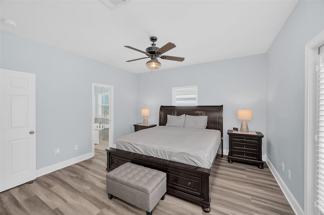 bedroom featuring visible vents, ensuite bath, light wood-style flooring, and baseboards