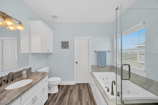 bathroom featuring toilet, vanity, wood finished floors, baseboards, and a tub with jets