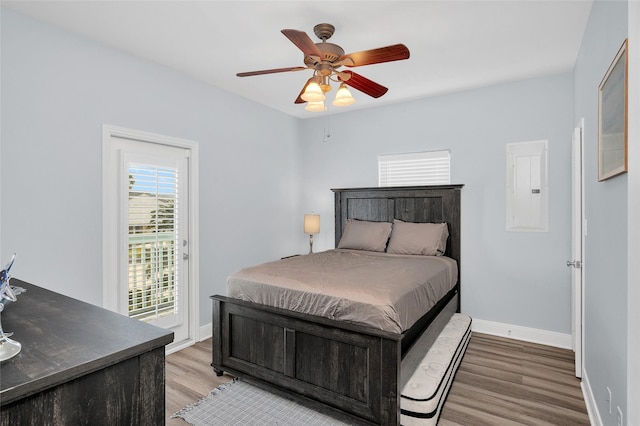 bedroom with a ceiling fan, baseboards, light wood-style floors, access to outside, and electric panel