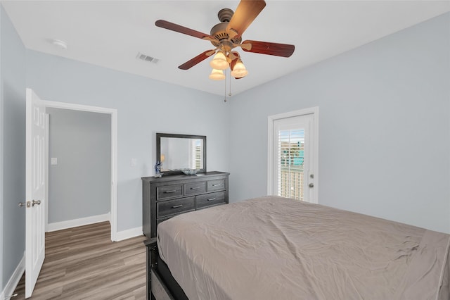 bedroom featuring baseboards, a ceiling fan, visible vents, and light wood-style floors