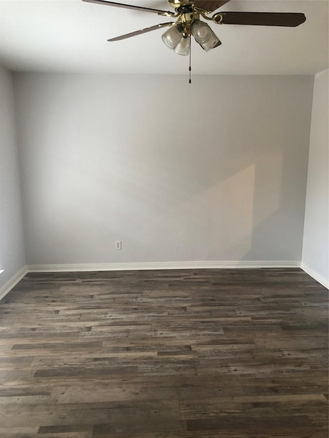 unfurnished room featuring dark wood-style floors, ceiling fan, and baseboards