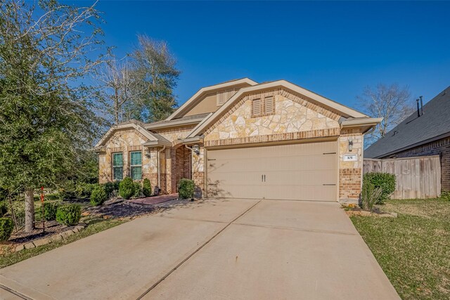 view of front of house featuring driveway, stone siding, an attached garage, fence, and brick siding